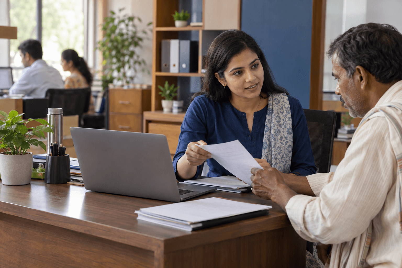 An office staff member reviewing a citizen request with a visitor